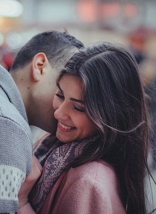 Un homme et une femme s’embrassant dans une ville.